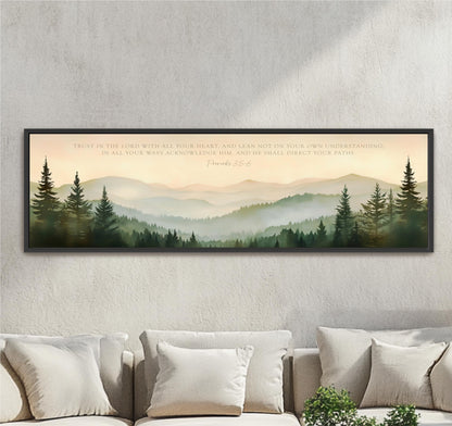 a large framed print of a serene mountain landscape with pine trees, set against a pale blue sky.