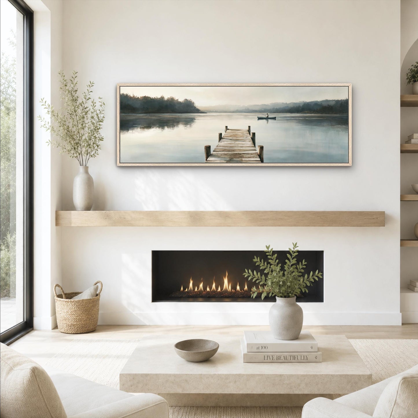 a serene living room with a fireplace, a large window, and a painting of a dock with a boat on the water. The room has a minimalist and modern design, with a white color scheme and natural elements like plants and a woven basket.
