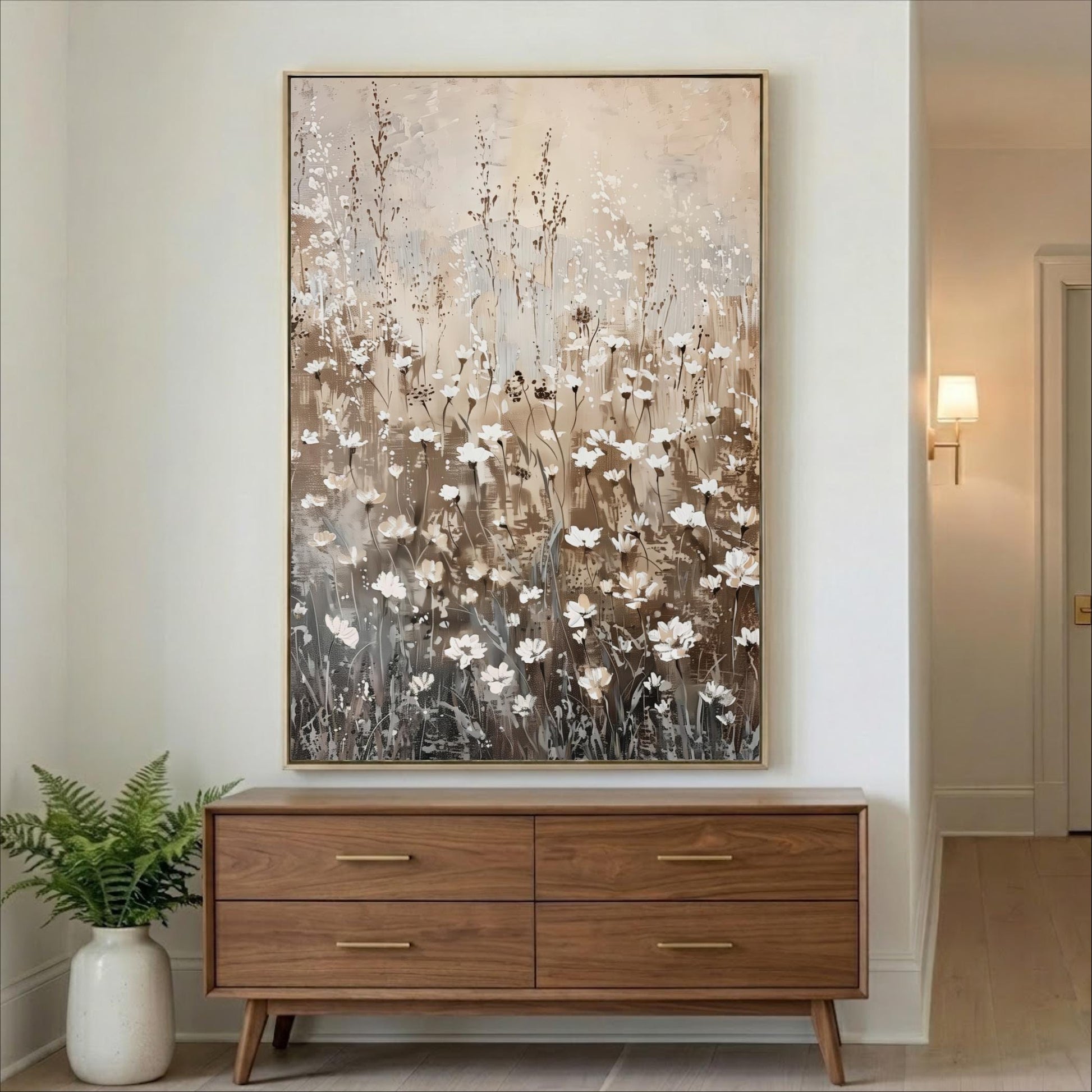 a large painting of white flowers hanging on a wall above a wooden dresser with four drawers.