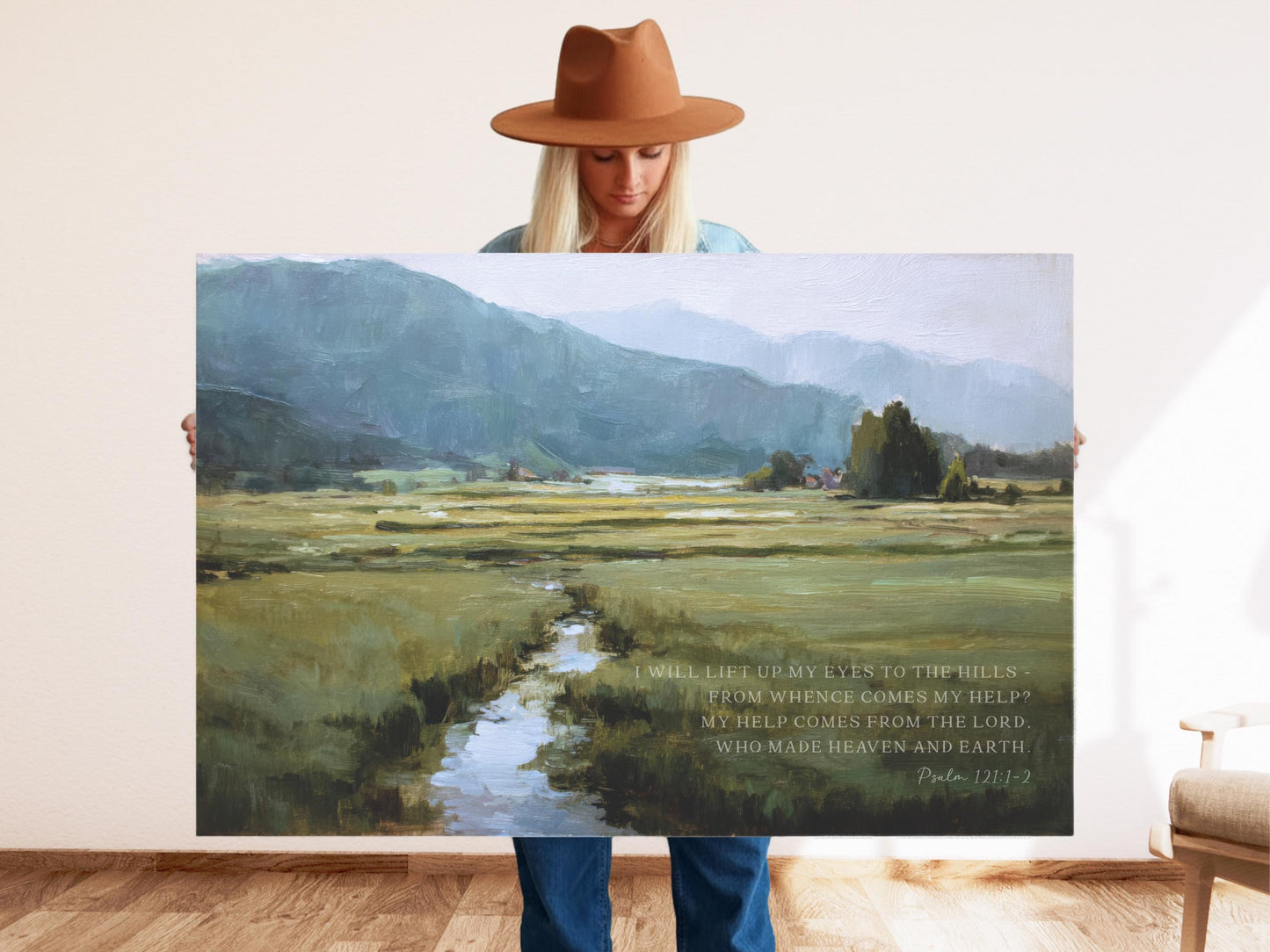 a woman holding up a painting with a quote on it