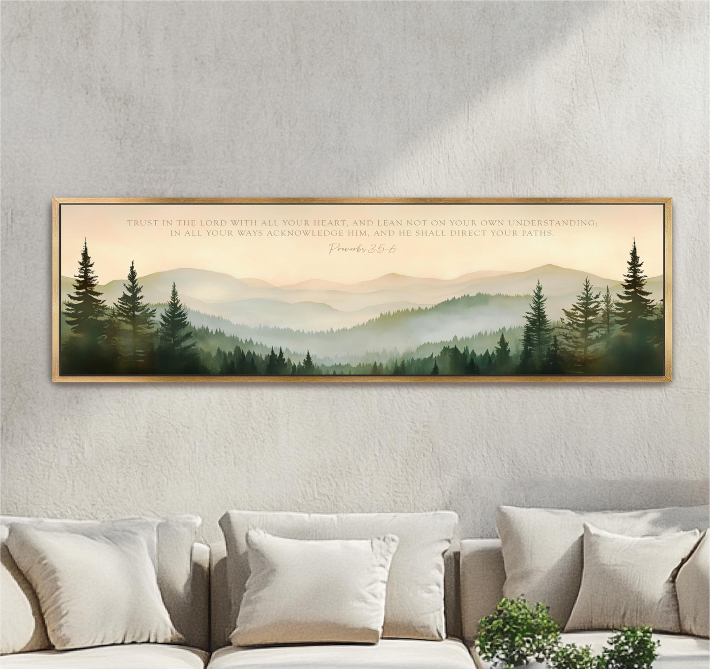 a large framed print of a serene mountain landscape with pine trees, hanging on a wall above a couch.