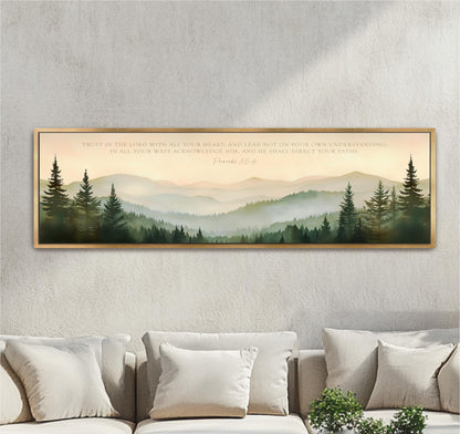 a large framed print of a serene mountain landscape with pine trees, hanging on a wall above a couch.