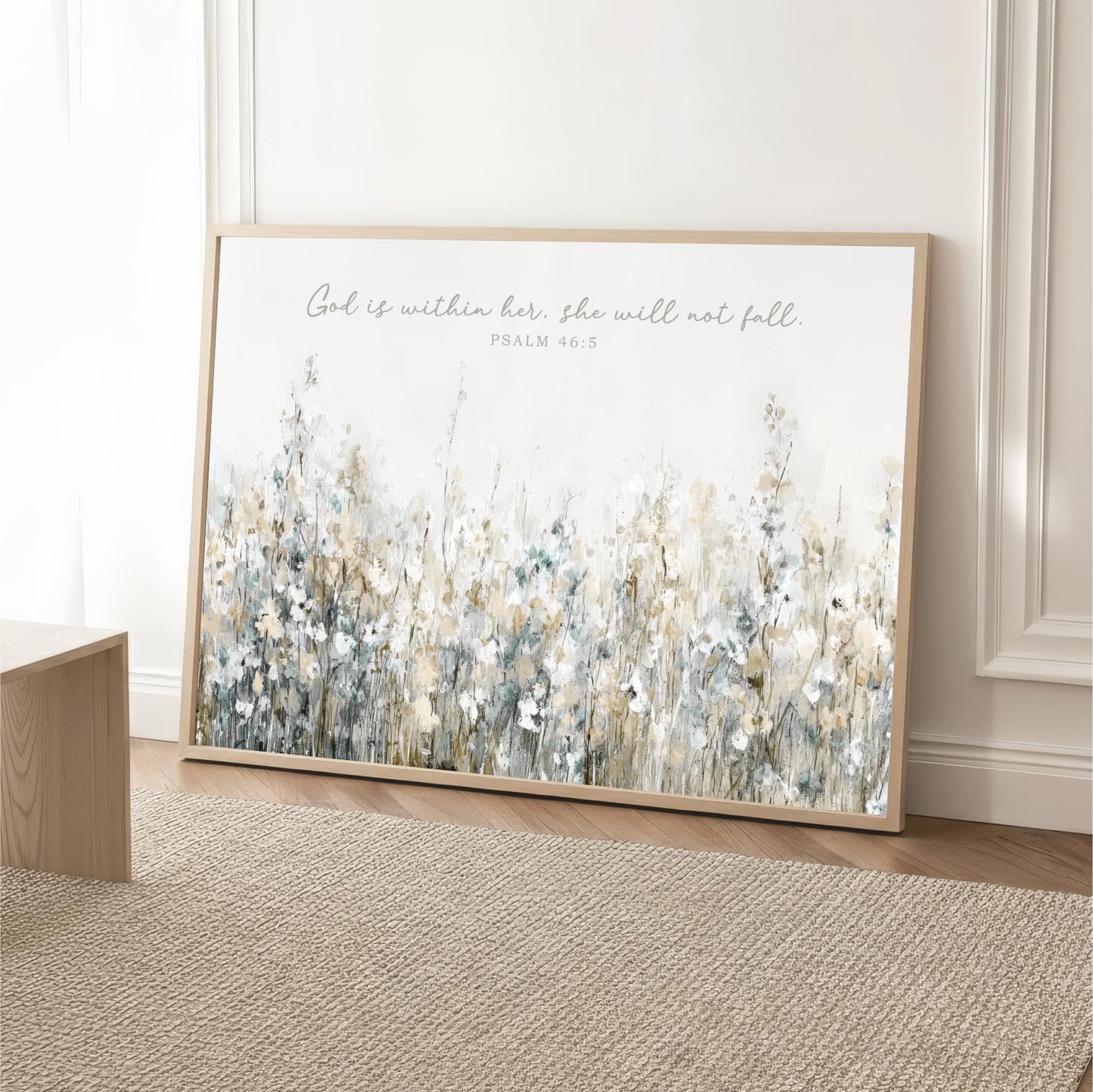 A framed print of a floral landscape with the text "God is within her, she will not fall" and the Bible verse " Psalm 46:5" is displayed on a wall.
