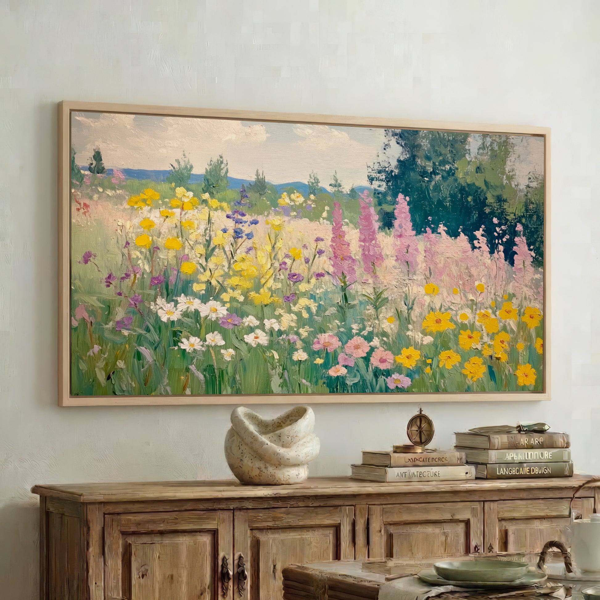 a large painting of a colorful garden with flowers hanging on a wall above a wooden cabinet.