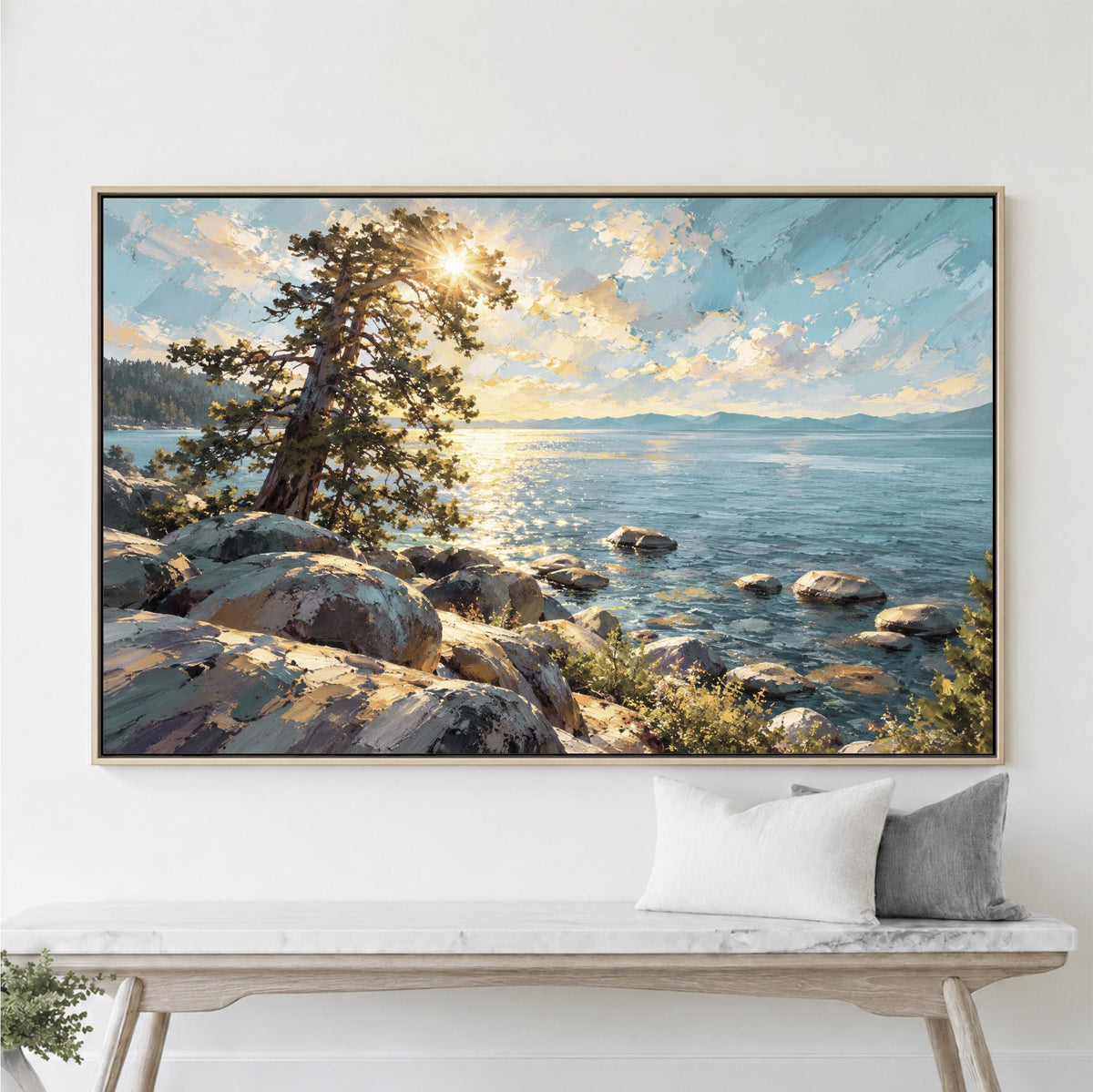 a large framed painting of a serene landscape with a rocky shore, a tree, and a body of water reflecting the sky.
