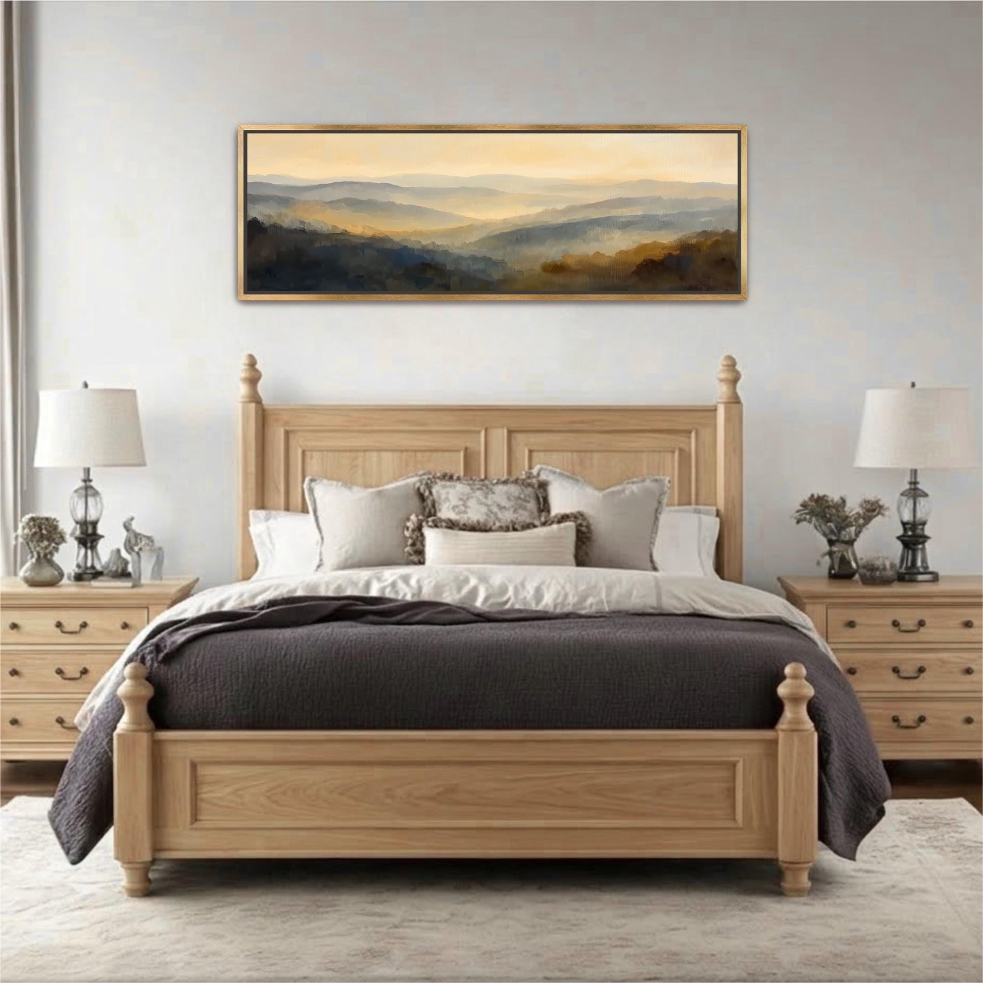 a large wooden bed with a gray comforter and pillows, flanked by two nightstands with lamps. Above the bed is a large painting depicting a landscape scene.