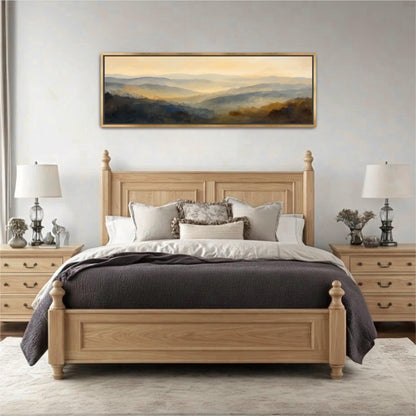 a large wooden bed with a gray comforter and pillows, flanked by two nightstands with lamps. Above the bed is a large painting depicting a landscape scene.