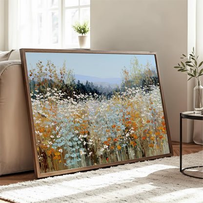 a large framed painting of a field of flowers, with a mix of blue, orange, and white colors, displayed on a wooden stand in a living room.