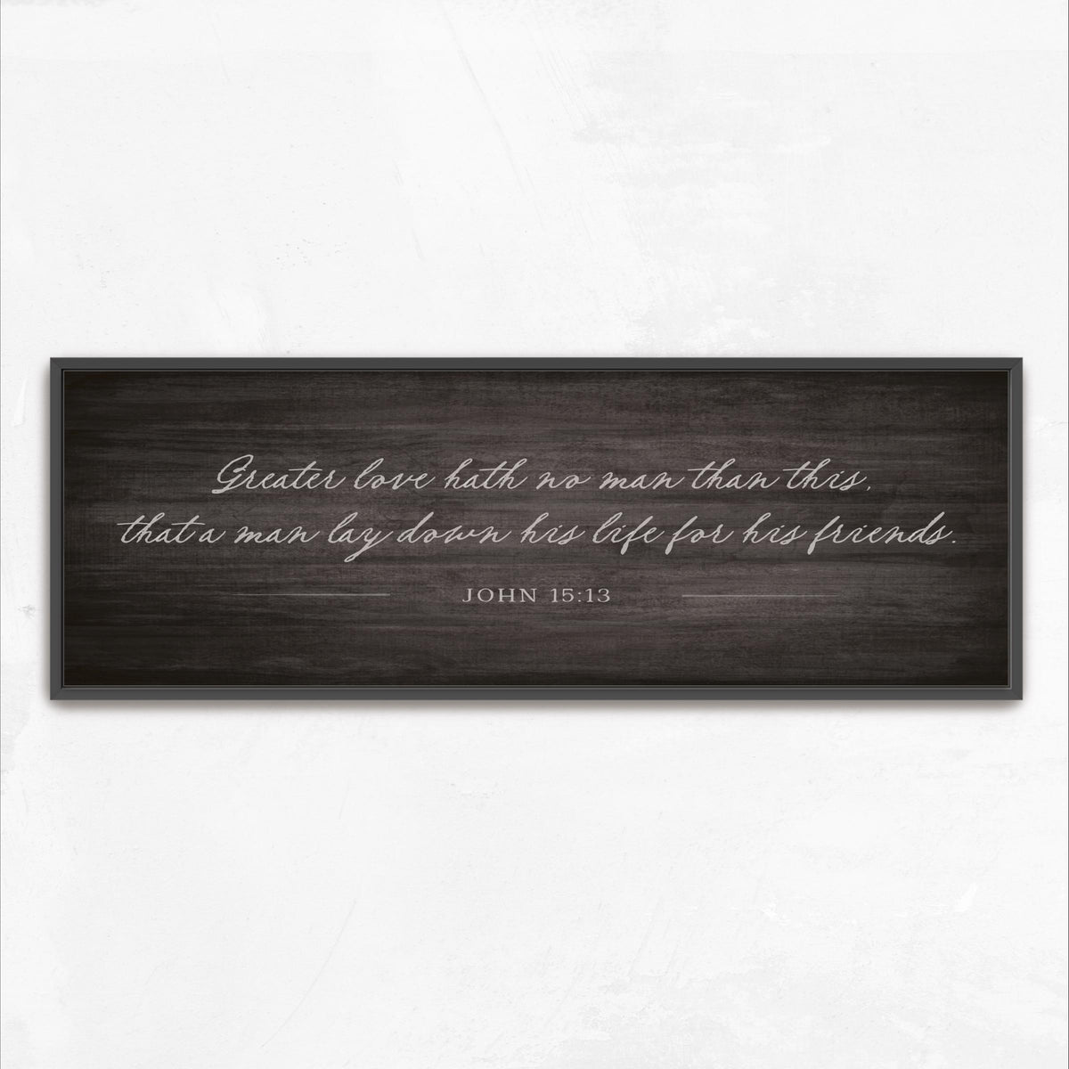 a black and white photograph of a wooden sign with a quote from the Bible verse John 15:13.