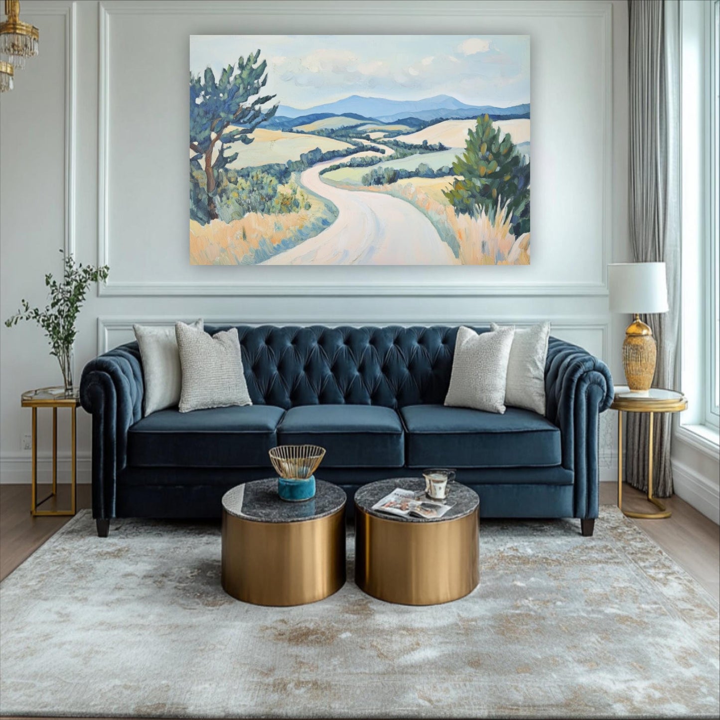 a living room with a blue tufted sofa, two round coffee tables, and a large landscape painting on the wall.