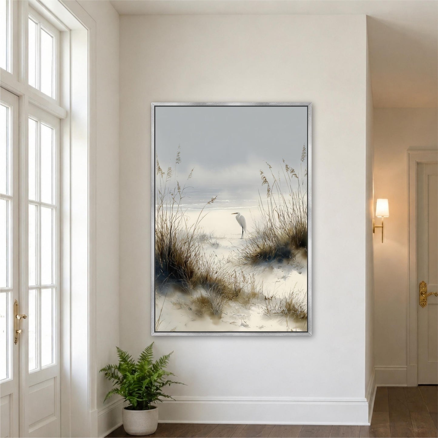a large framed painting of a serene beach scene with a bird standing on the sand and tall grasses in the background.