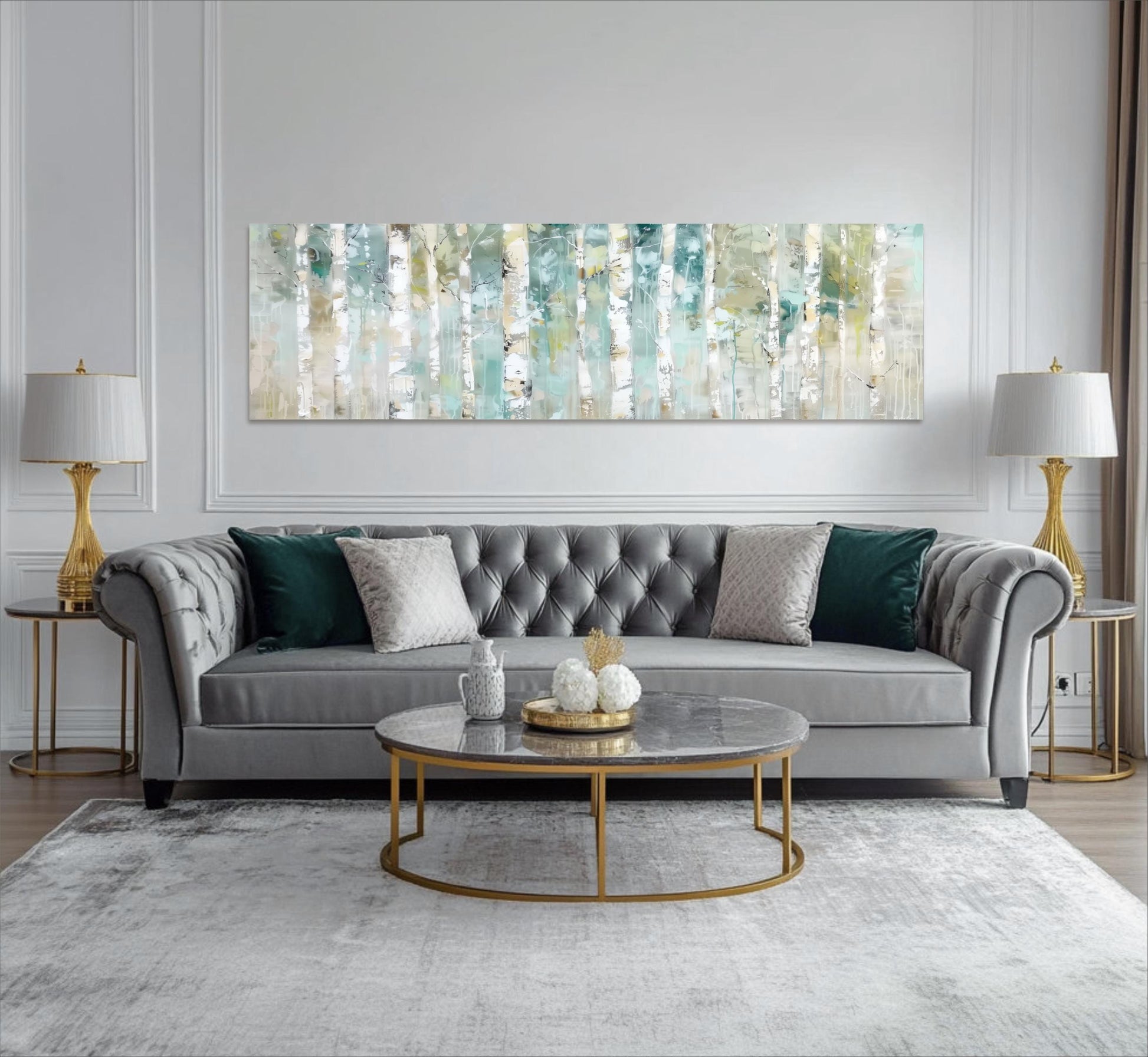 a modern living room with a gray tufted sofa, a round coffee table, and two gold lamps on either side of the sofa. Above the sofa, there is a large abstract painting with a repeating pattern of green and white stripes.