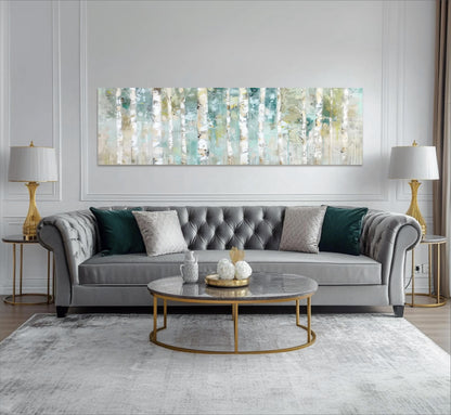 a modern living room with a gray tufted sofa, a round coffee table, and two gold lamps on either side of the sofa. Above the sofa, there is a large abstract painting with a repeating pattern of green and white stripes.