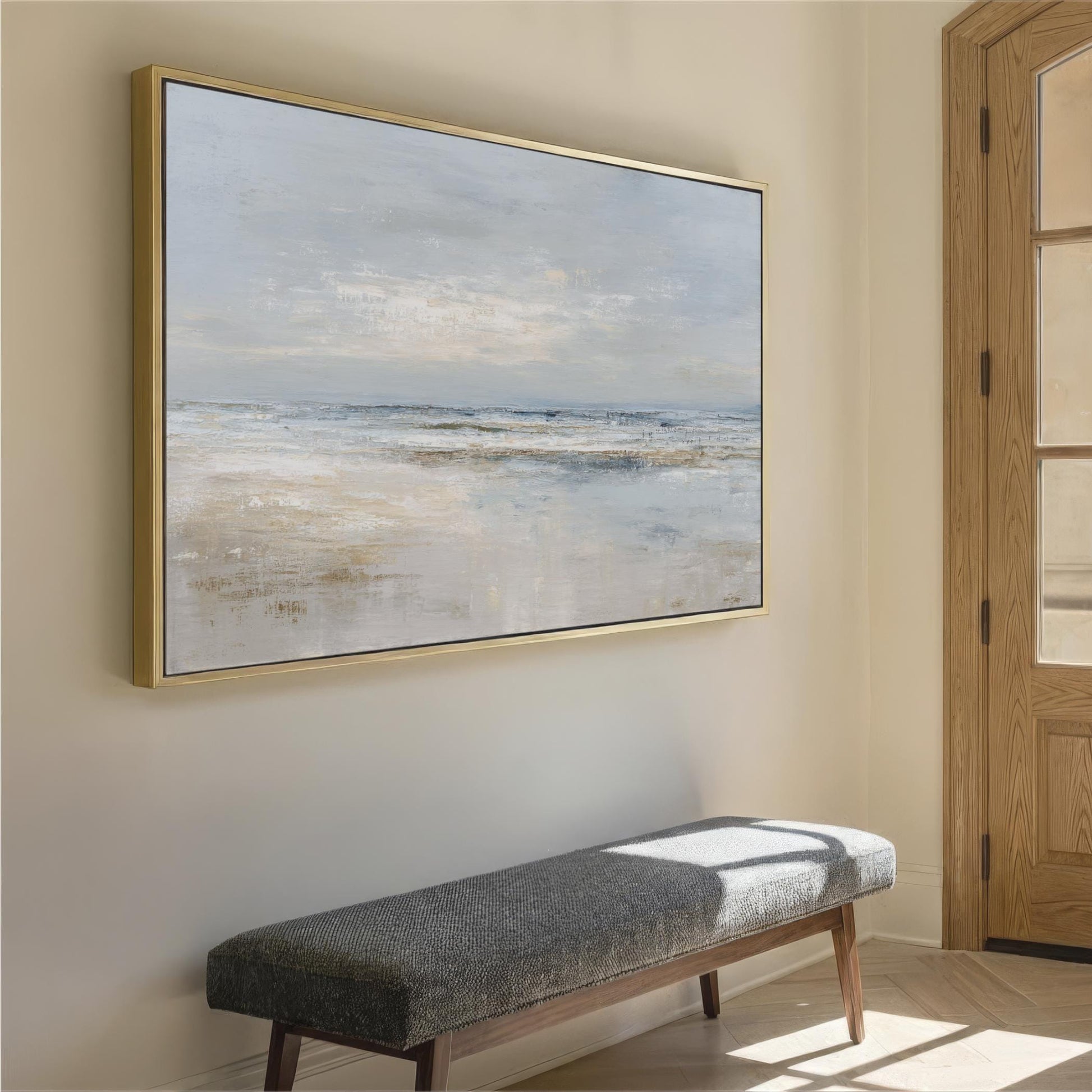 a large, framed painting of a serene landscape hanging on a wall, with a wooden bench placed in front of it.