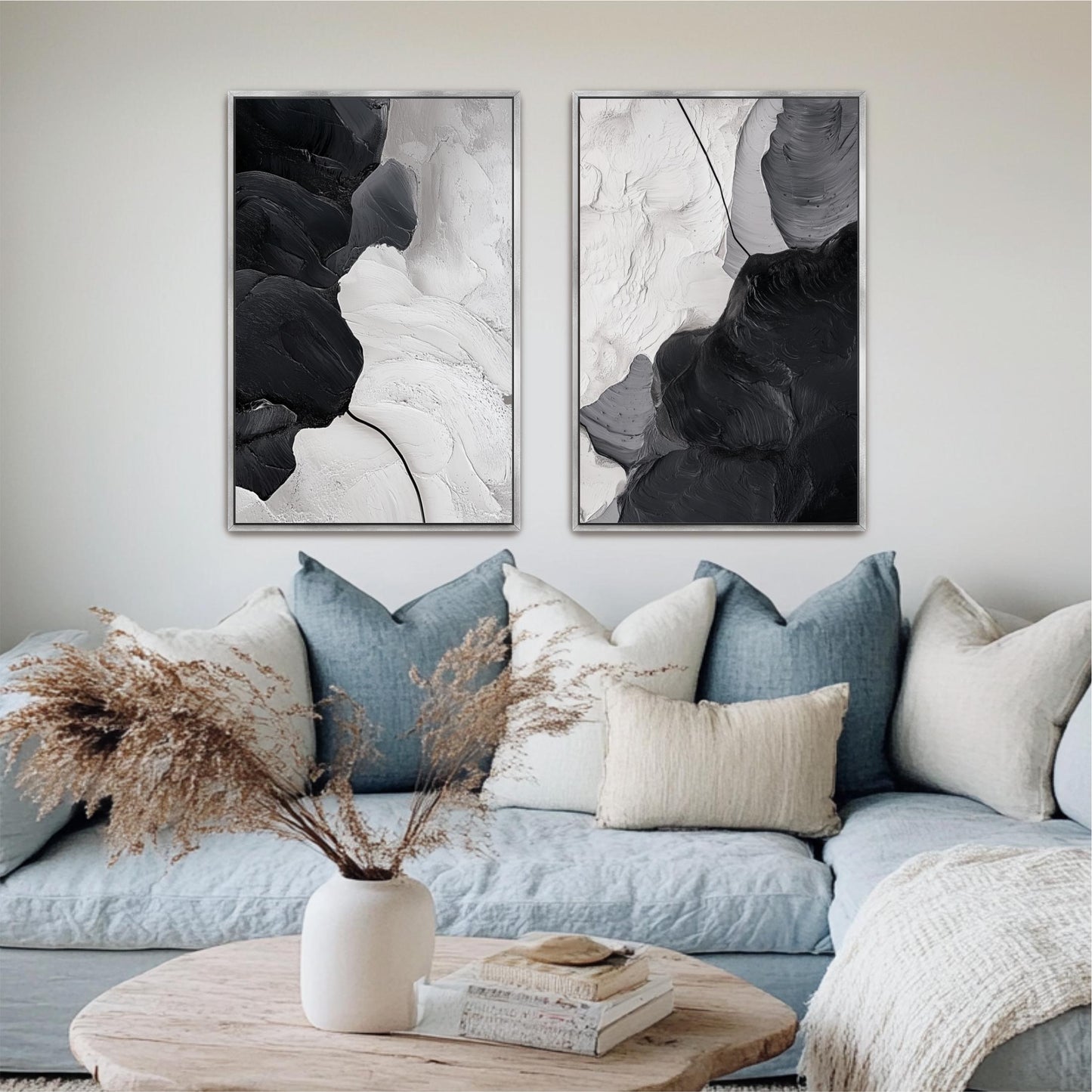 a living room with a blue couch, a wooden coffee table, and two abstract paintings hanging on the wall above the couch.