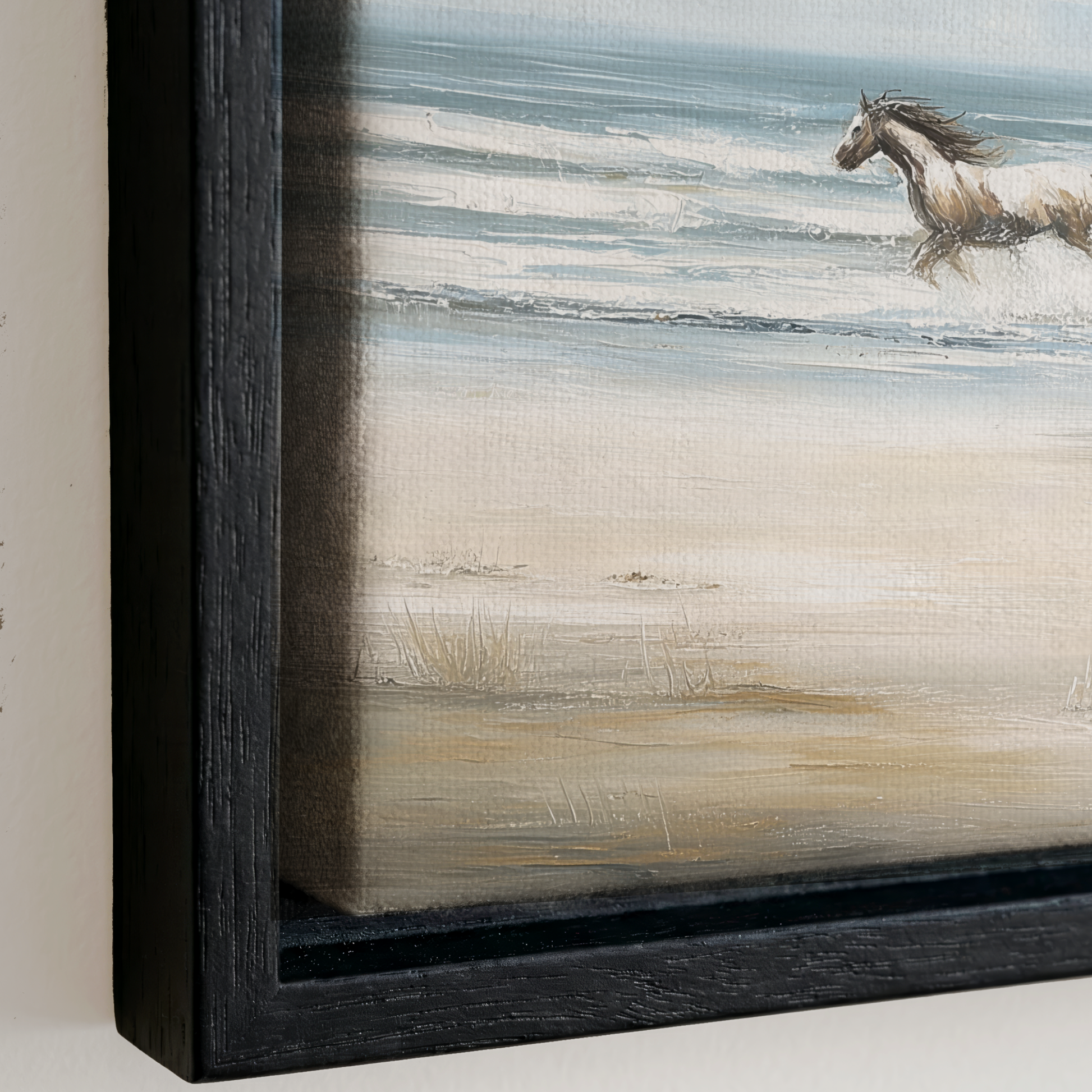 a horse running on a beach, with the ocean in the background.